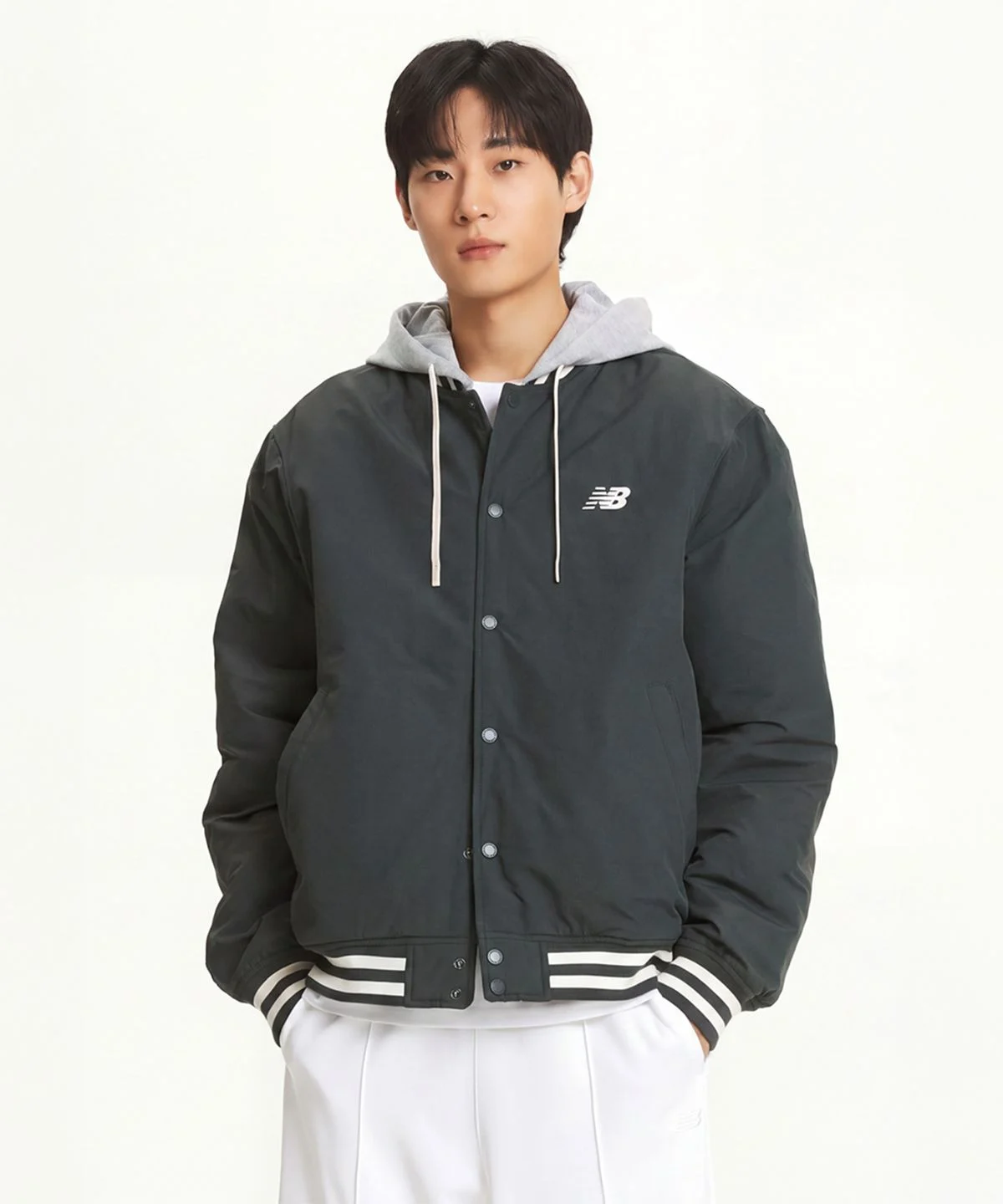 침대 위에 패딩 조끼 본체와 분리된 후드를 나란히 펼쳐놓고 디테일을 촬영한 모습