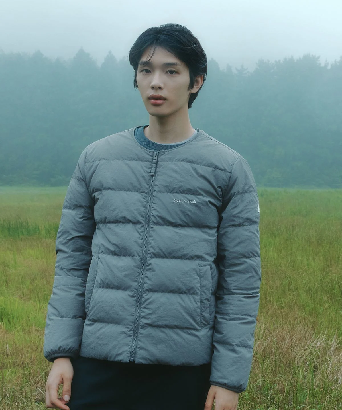 집 앞 공원에서 자켓을 입고 활동적인 포즈를 취하며 가벼운 소재감을 보여주는 전신 샷