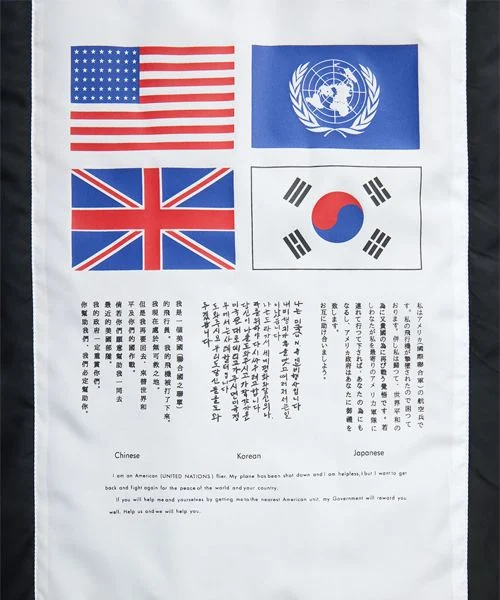 자켓의 왼쪽 소매에 달린 상징적인 레드 태그와 유틸리티 포켓이 선명하게 보이는 클로즈업 사진