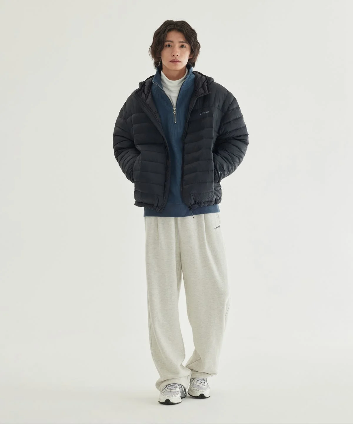 패딩을 작게 접어서 전용 패커블 주머니에 쏙 집어넣고 있는 손 모습