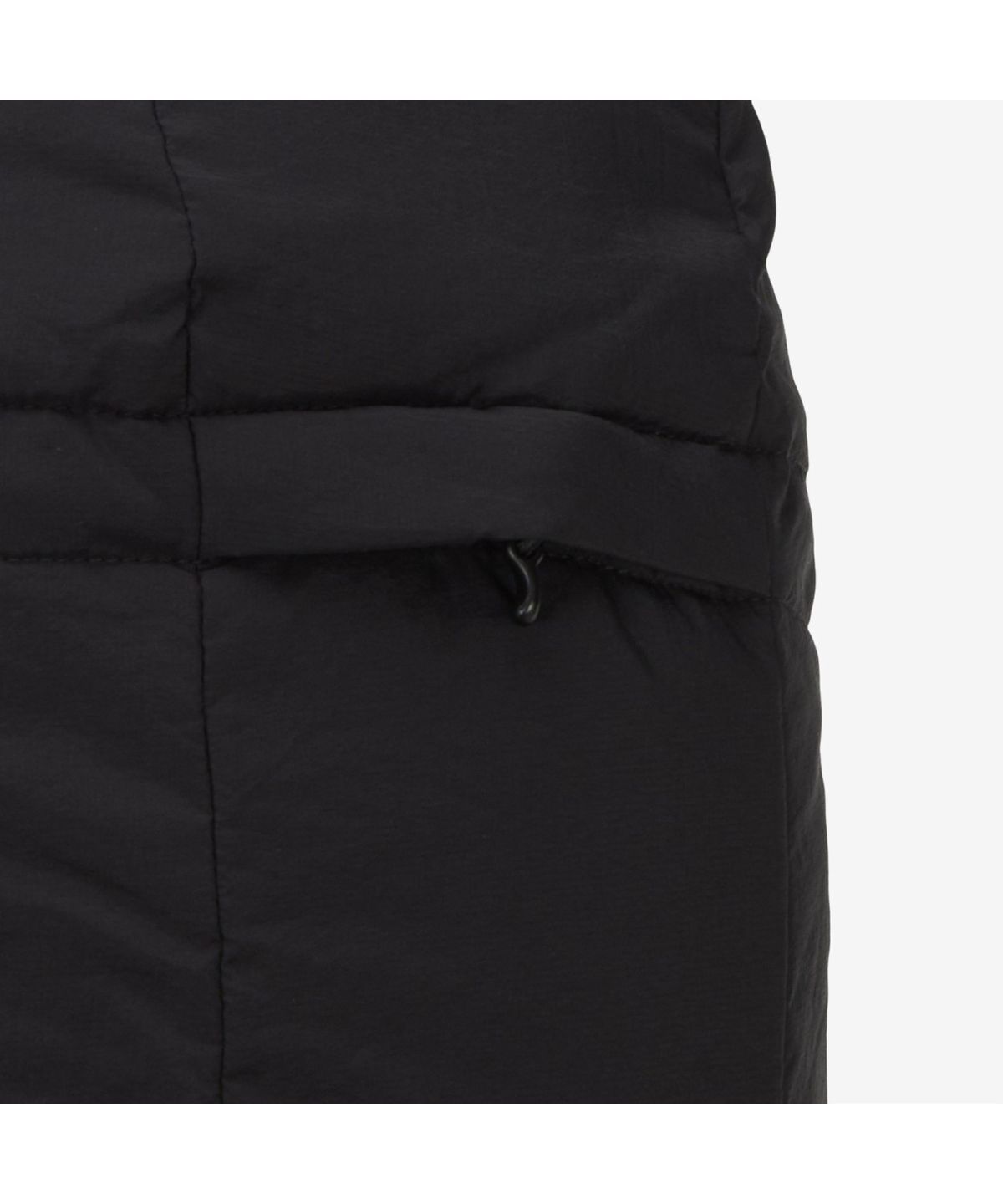 후드를 뒤집어쓰고 지퍼를 끝까지 올린 채 바람을 피하며 걷는 옆모습 디테일